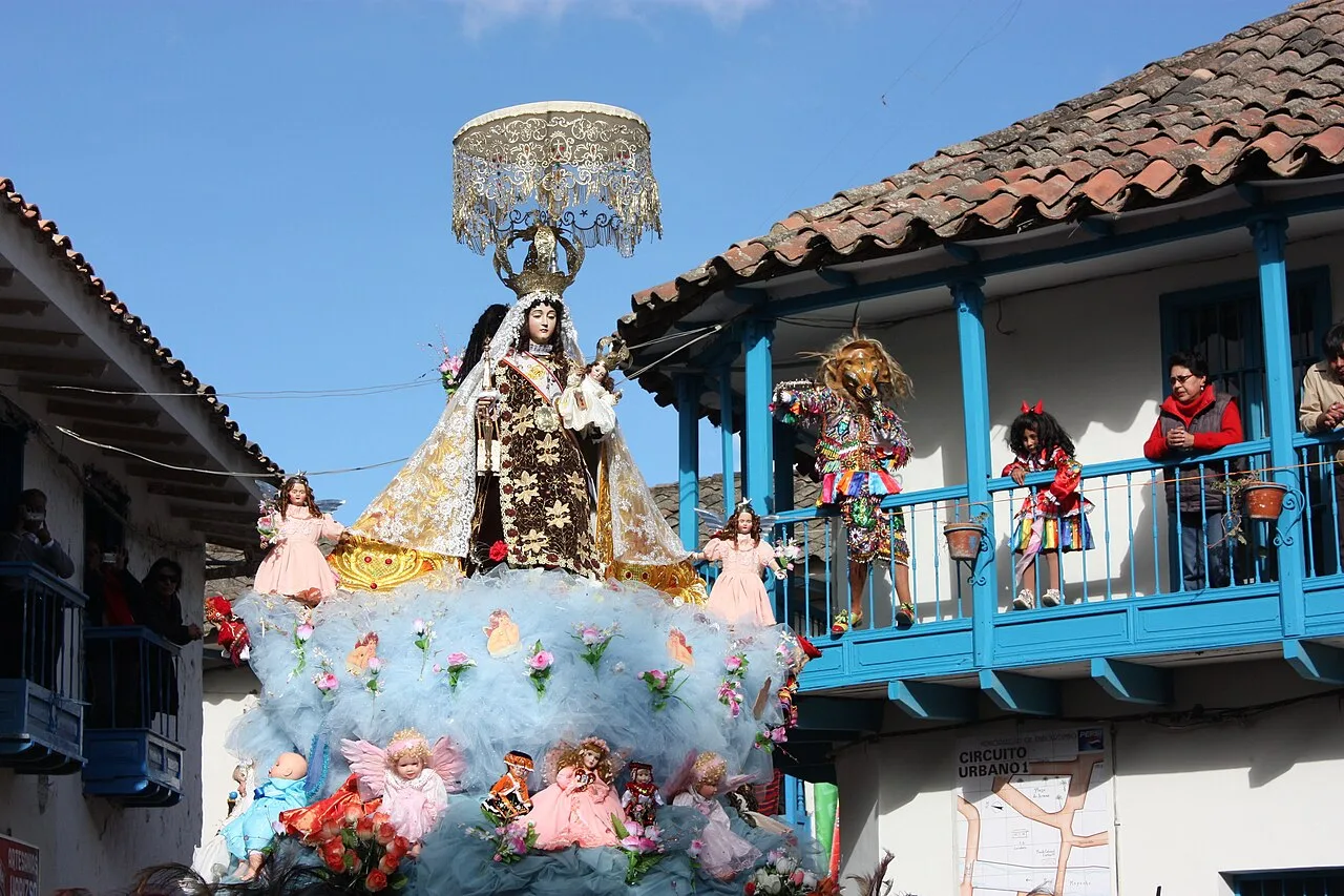 The Virgen del Carmen procession passing Paucartambo's blue balconies during the annual festival