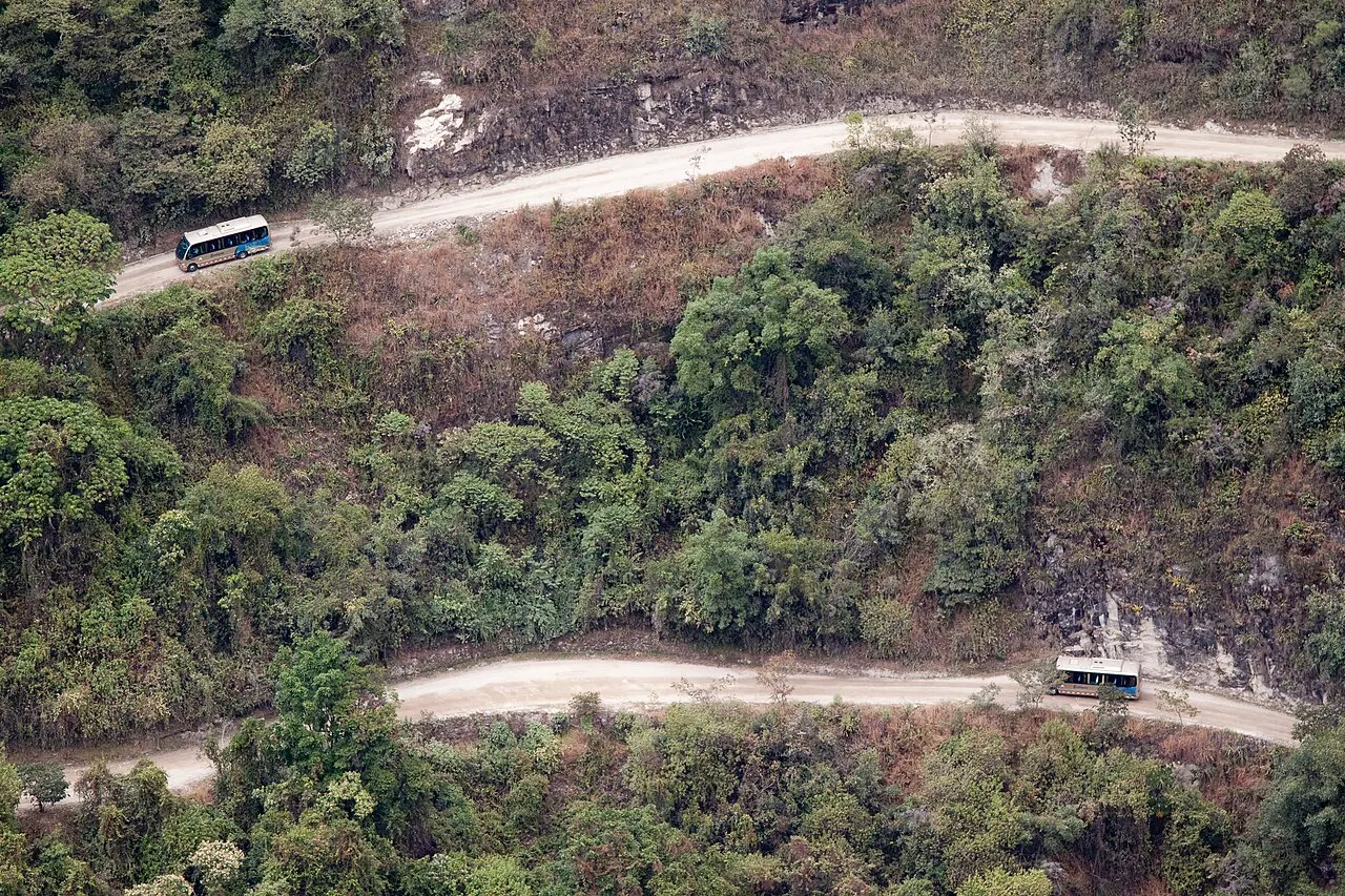 Shuttle buses climbing the forested switchback road below the Machu Picchu citadel