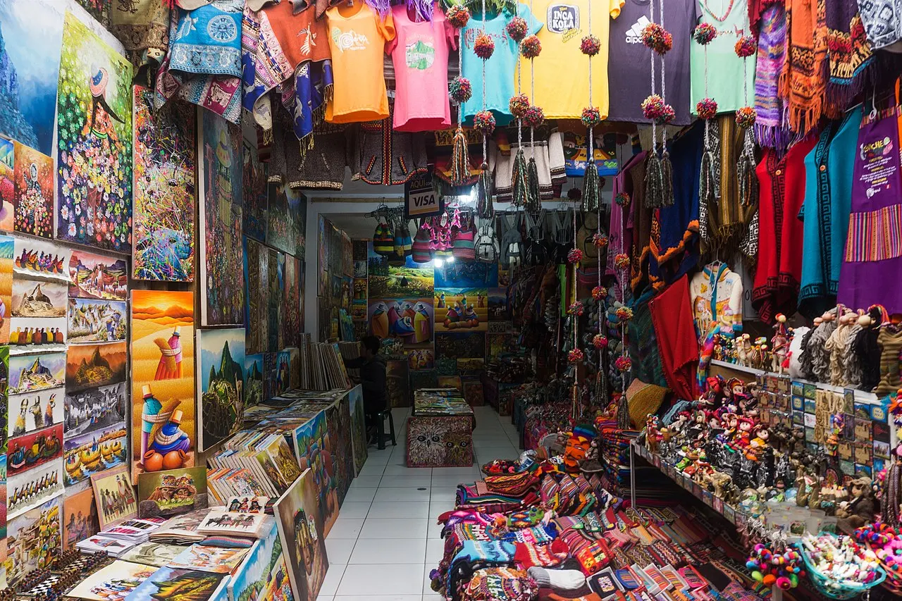 Bright craft and textile stalls filling the Pisac market on a busy day