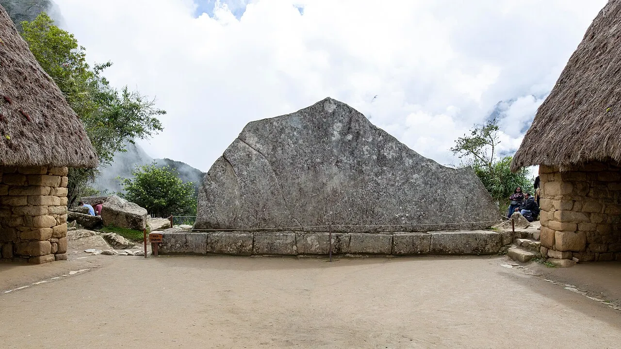 The flat face of the Sacred Rock at Machu Picchu echoing the silhouette of the mountain ridge behind it